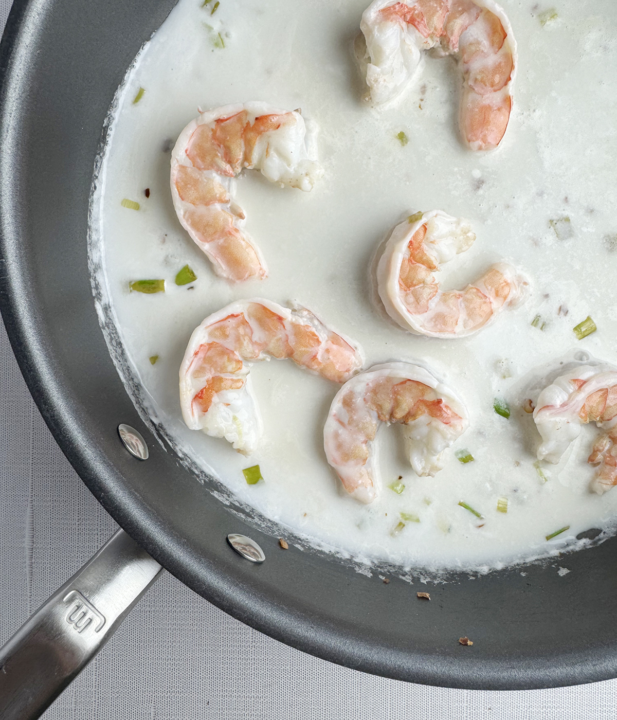 Shrimp in coconut sauce in a skillet.