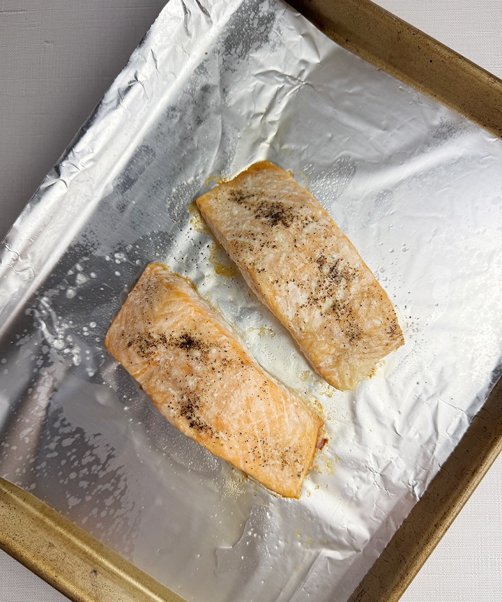 Cooked salmon filets on a baking sheet.