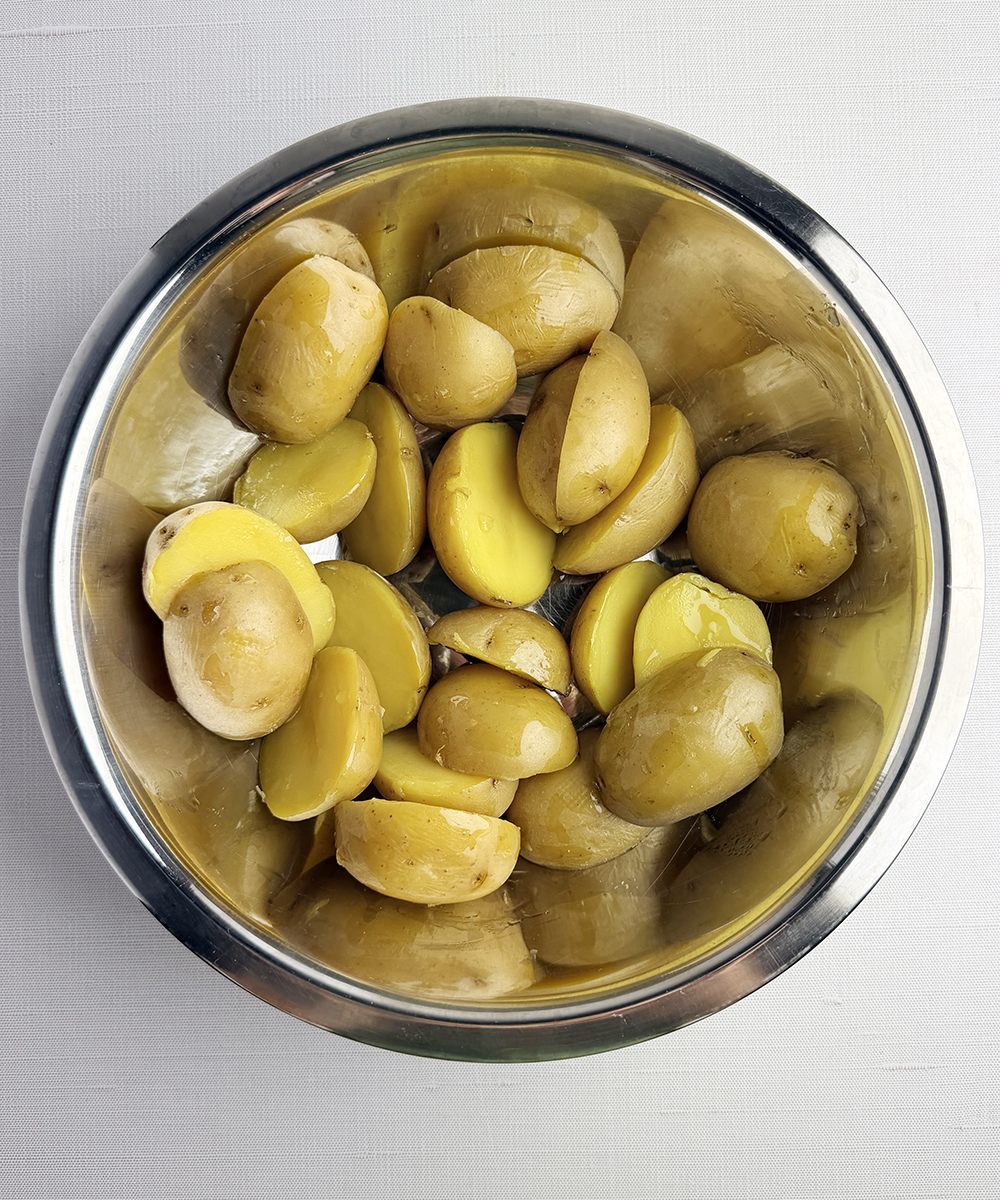 Halved baby potatoes in a bowl.