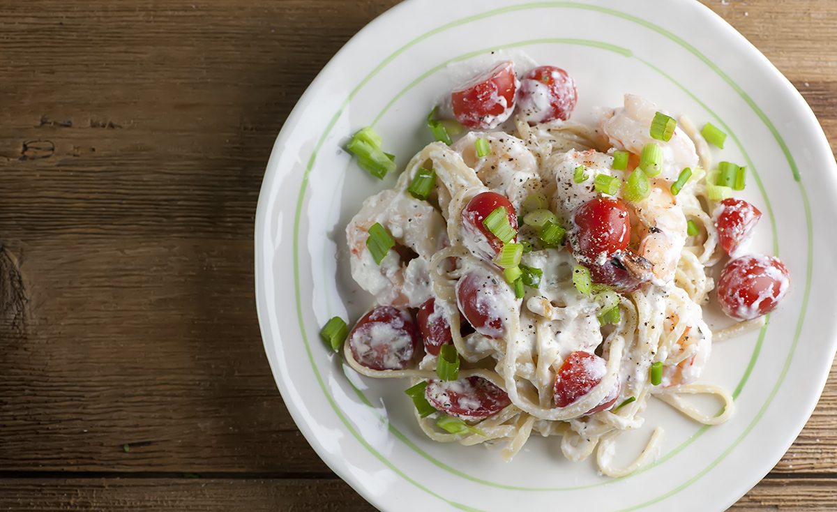 Pasta with feta cheese sauce and shrimp on a plate.