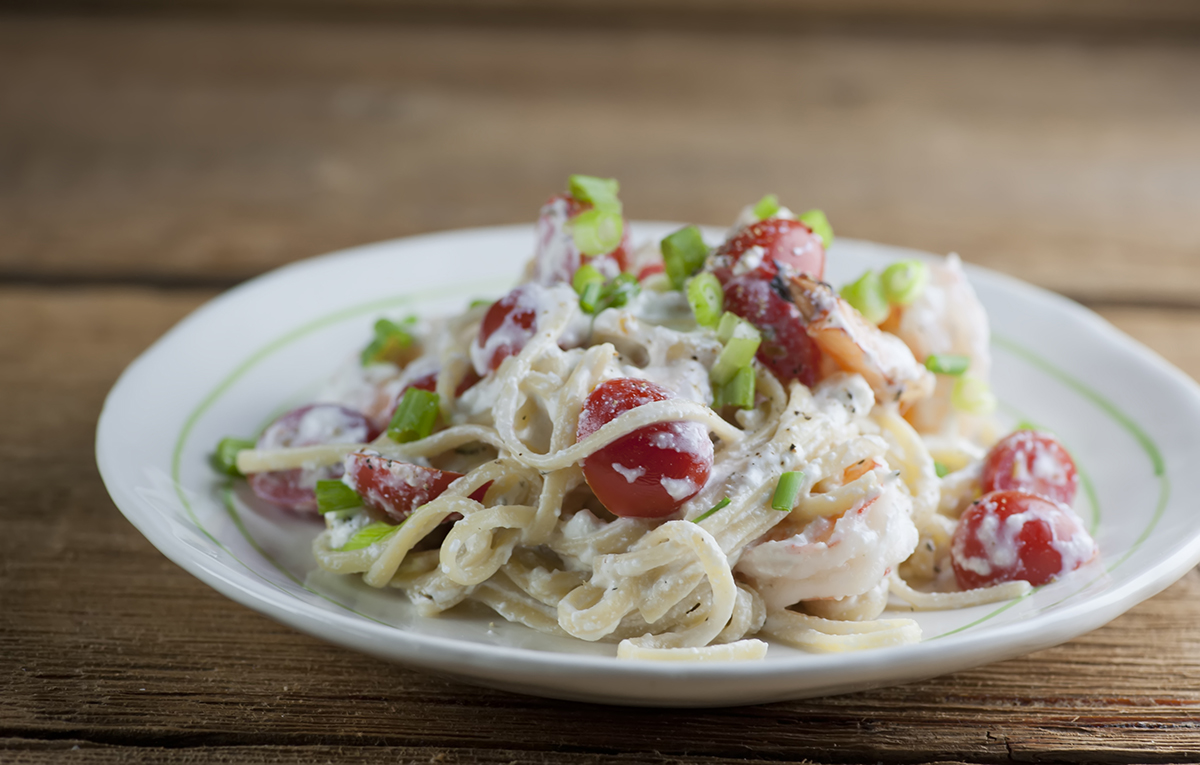 Plate of pasta with shrimp and feta cheese sauce.