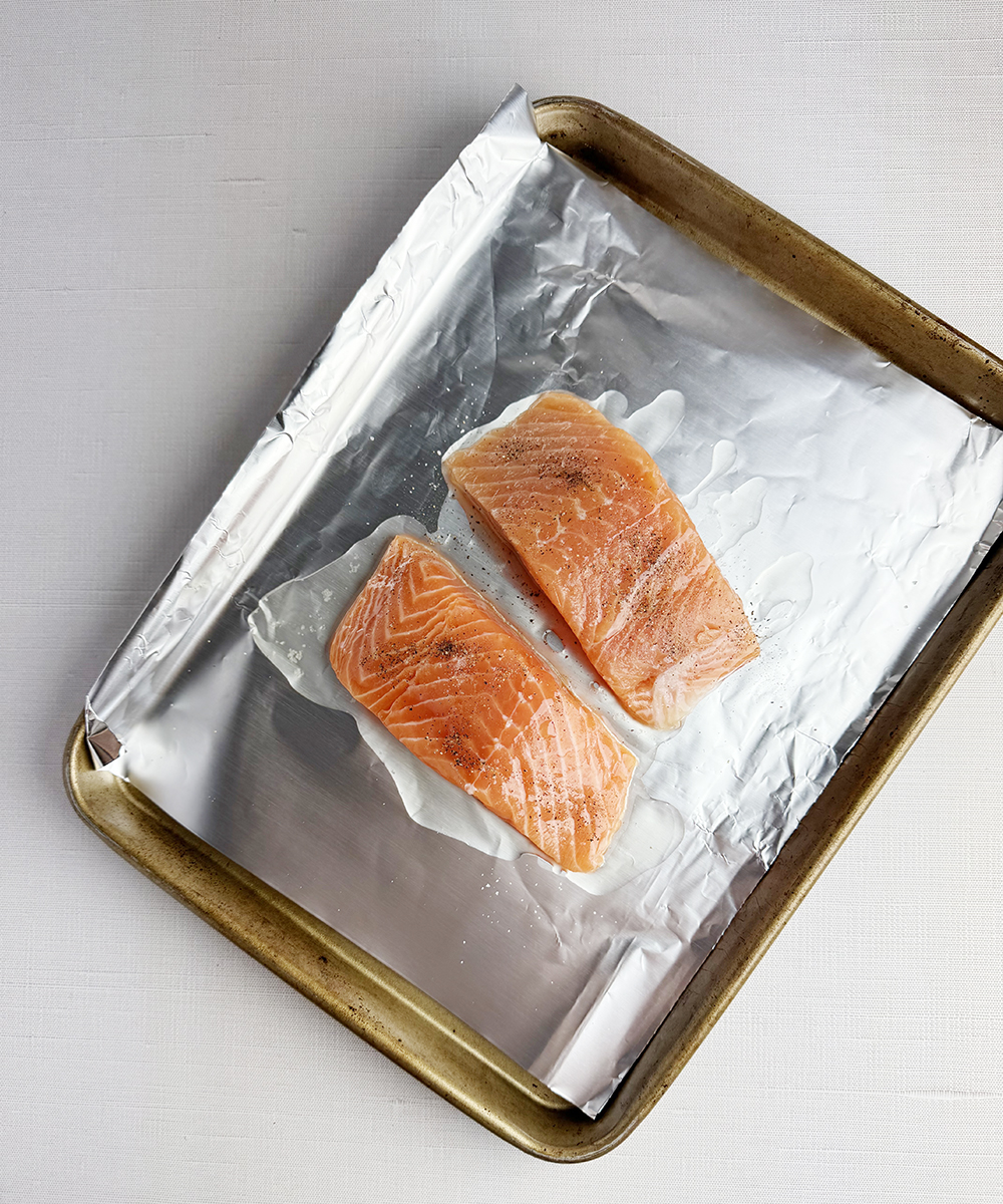 Salmon filets on a baking sheet ready for the oven.