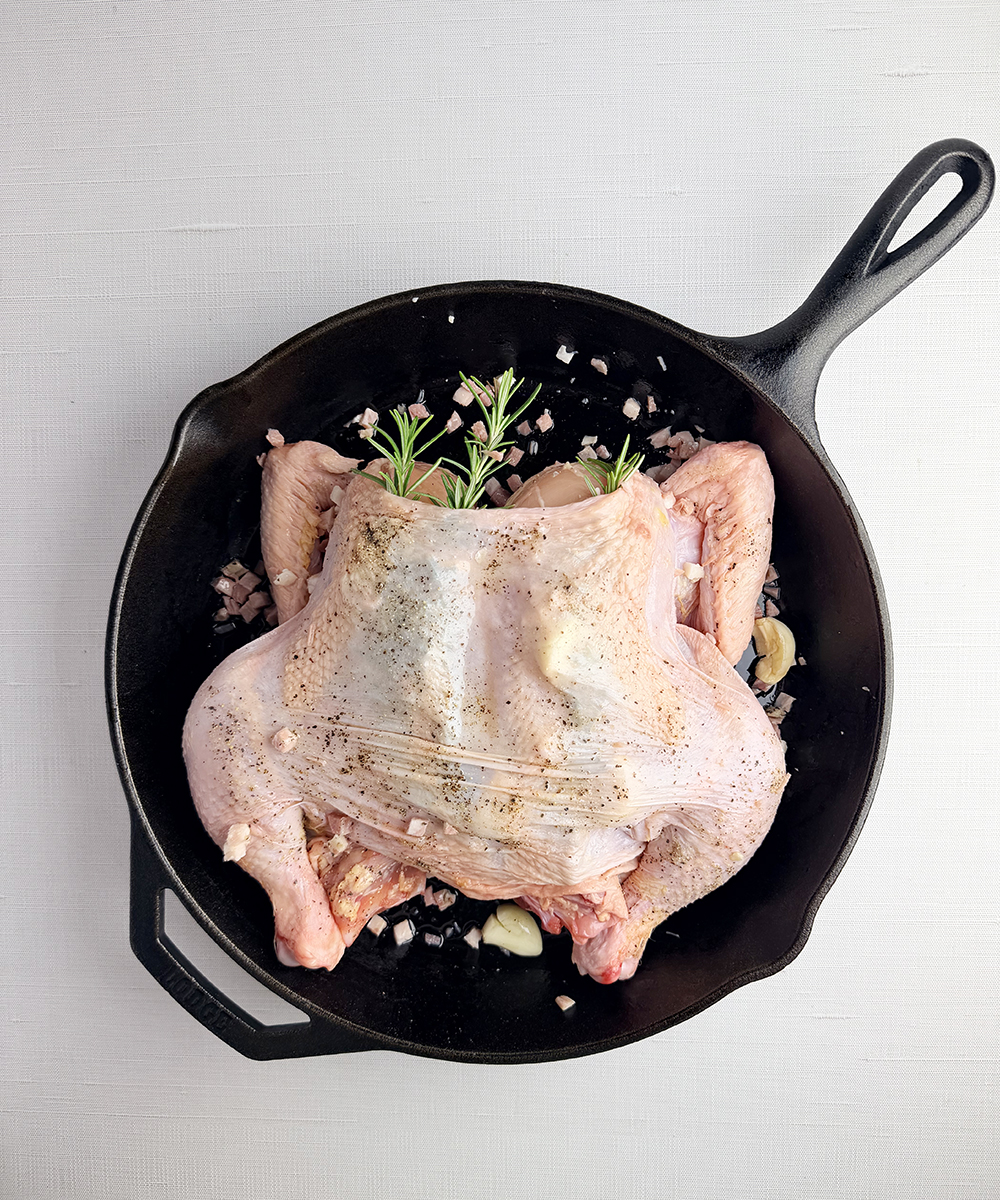 Spatchcoked chicken in a cast iron skillet.