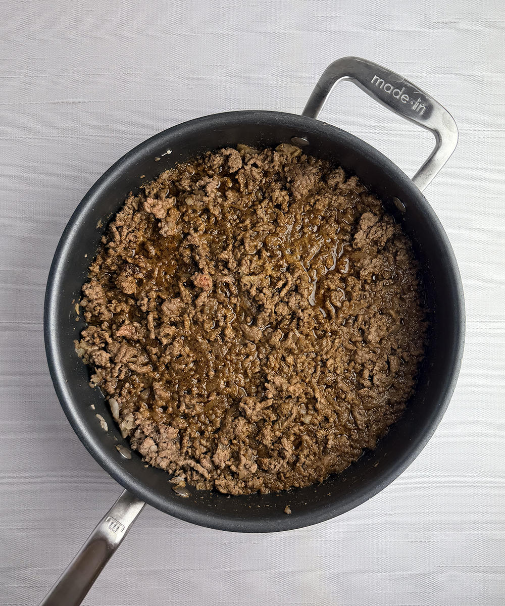 Spiced meat cooking in a skillet.