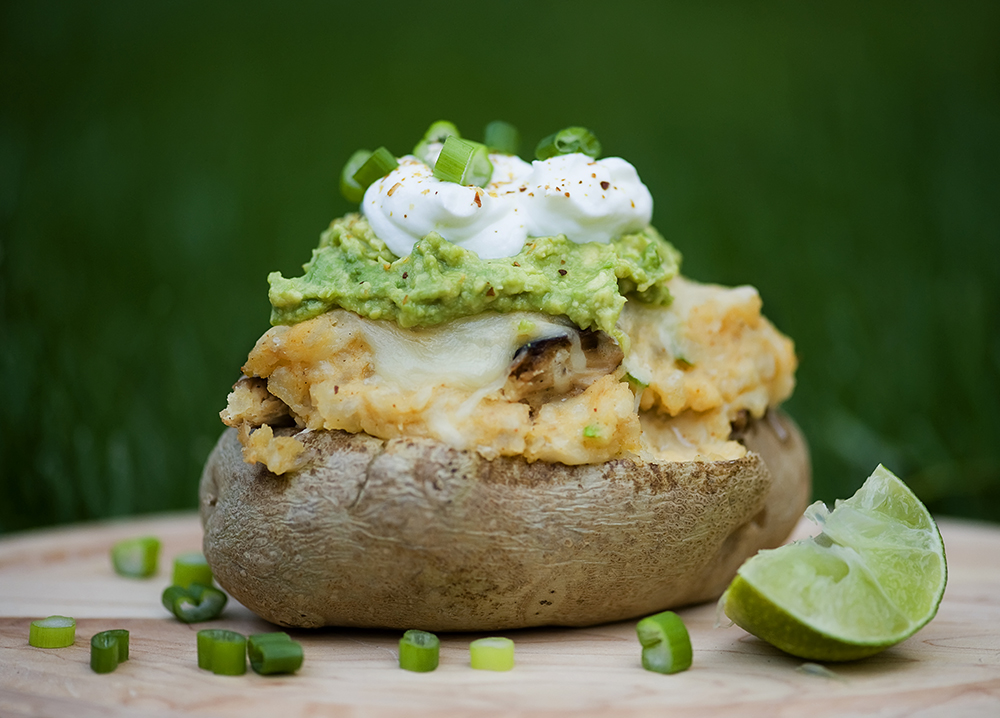 Stuffed taco potato with lime on the side.