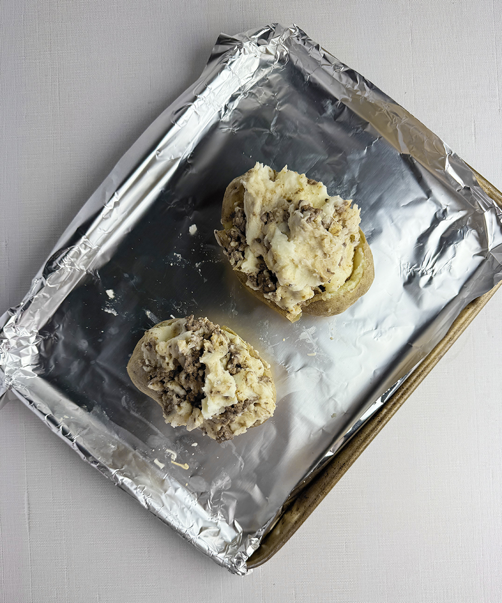 Stuffed taco potatoes on a cookie sheet.